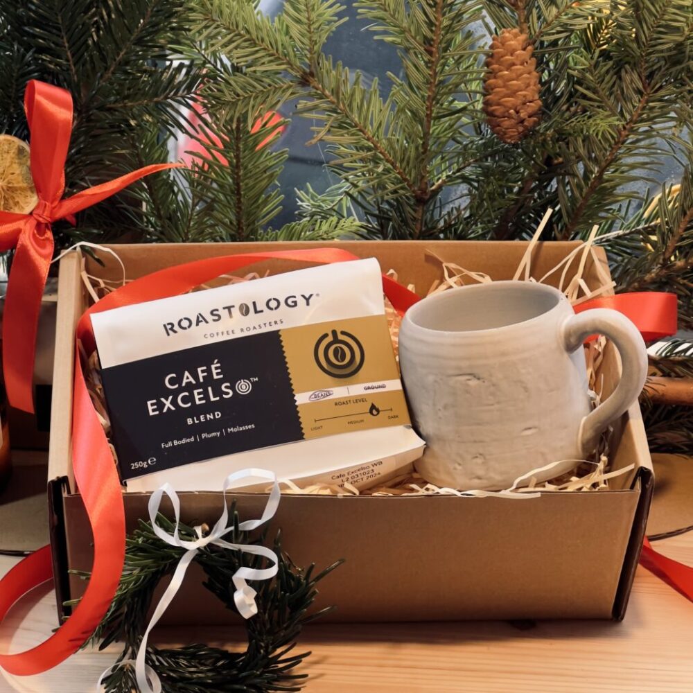 Chunky rustic off white mug and bag of coffee beans in a gift box for christmas